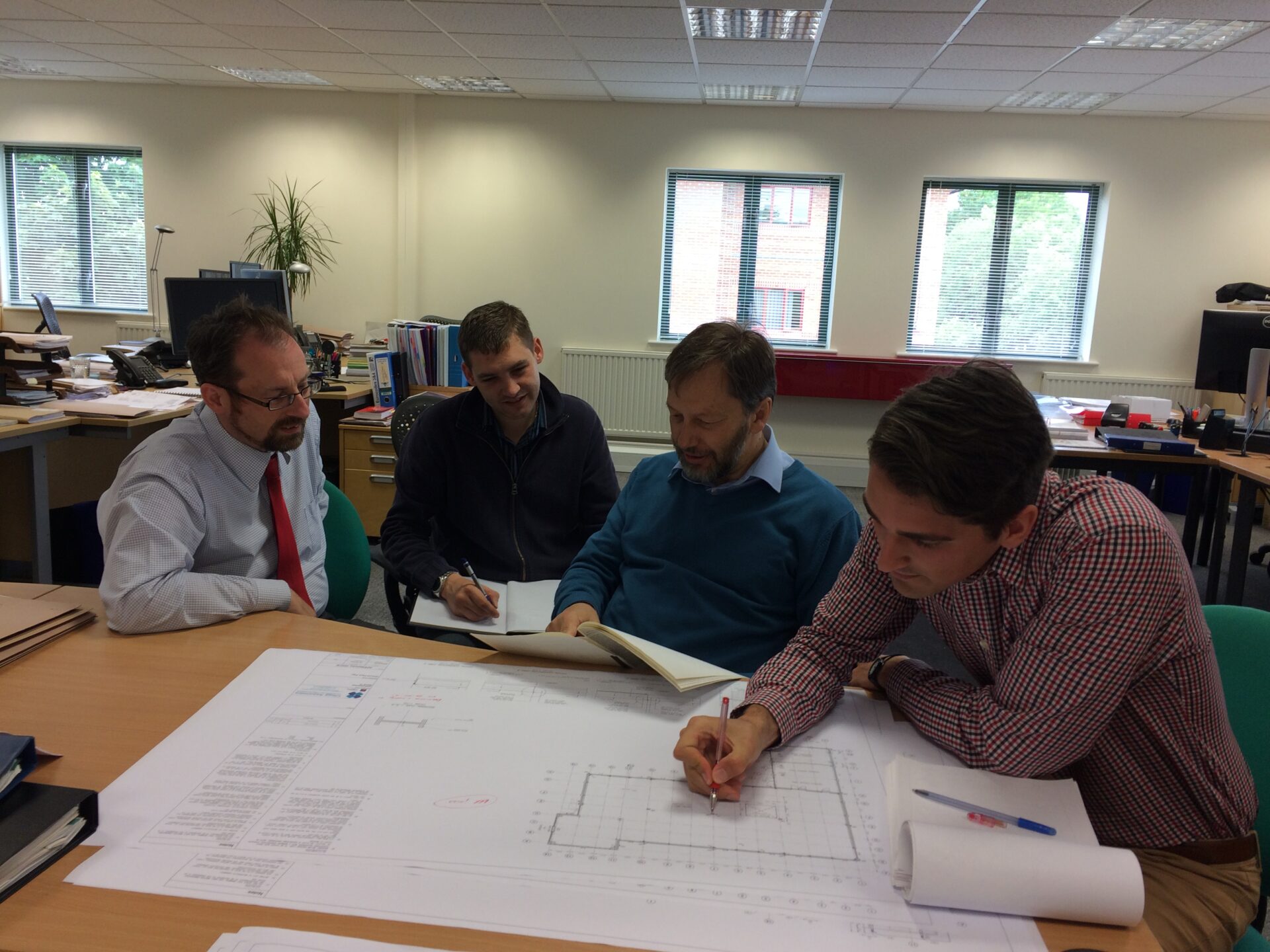 Clegg Associates team working on some diagrams in an office together.