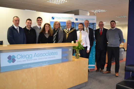 The Clegg associates team posing for the camera behind a reception desk.